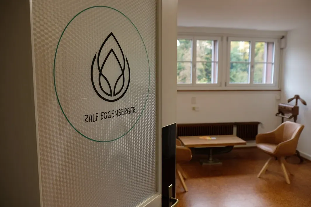 Eingang zum Praxisraum mit dem Ralfing-Logo auf der Glastür